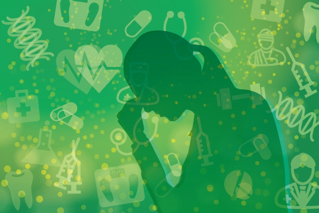 健康にストレスを抱える女性-緑背景