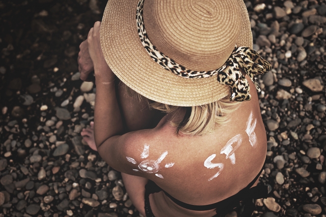 肌に日焼け止めで描かれた「SPF」の文字と太陽1