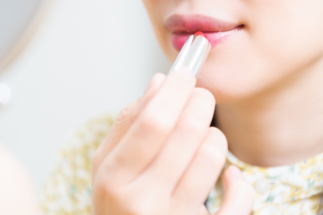 口紅を塗ってメイクする女性