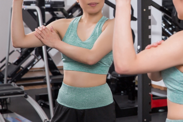 腕の筋肉をチェックする女性